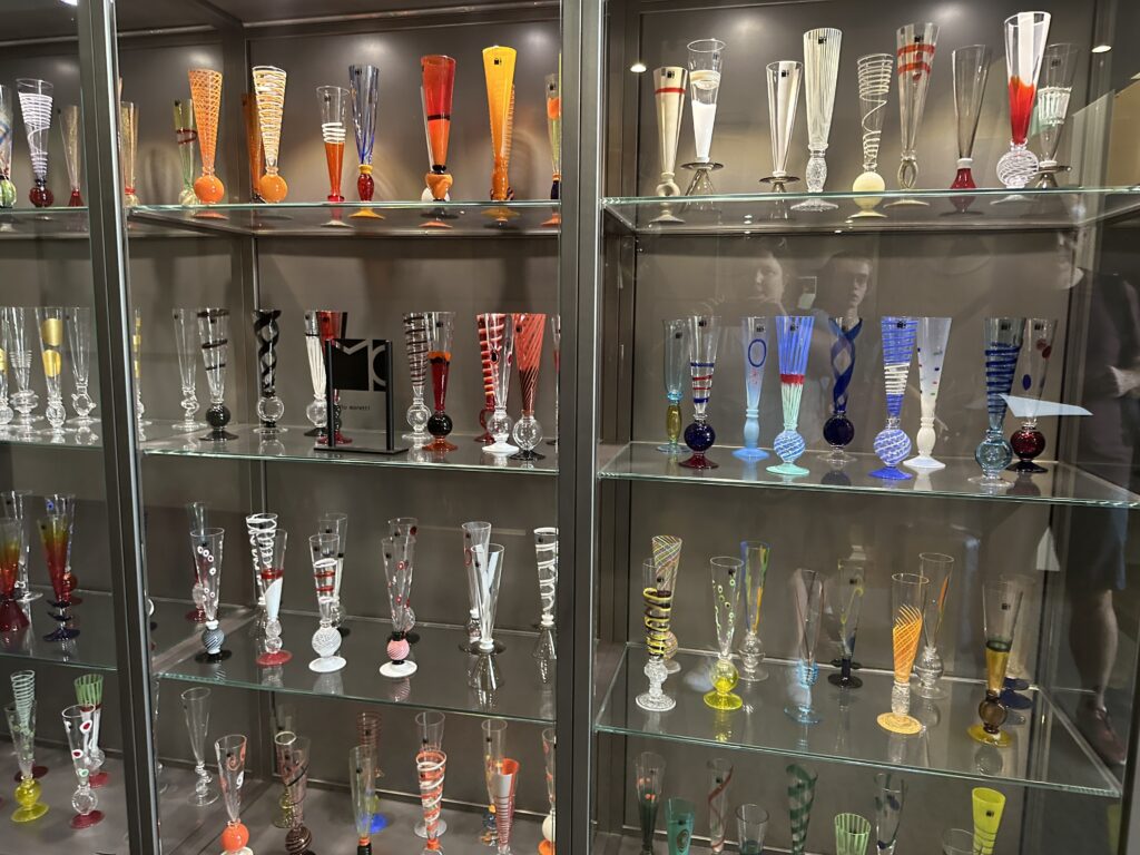 a glass display case with many different colored glass vases