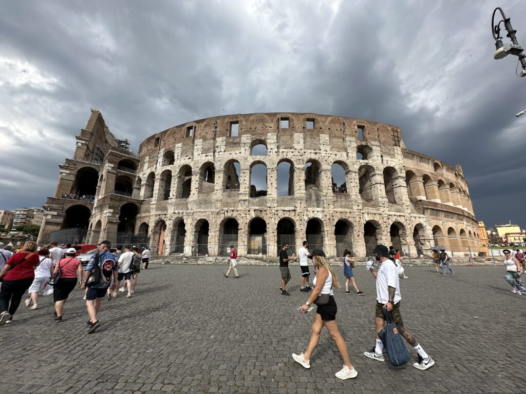a group of people walking in front of a large stone building