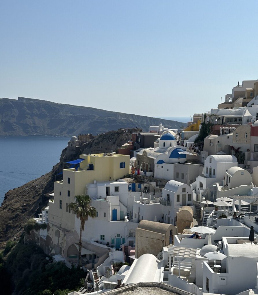 a white buildings on a hill by the water