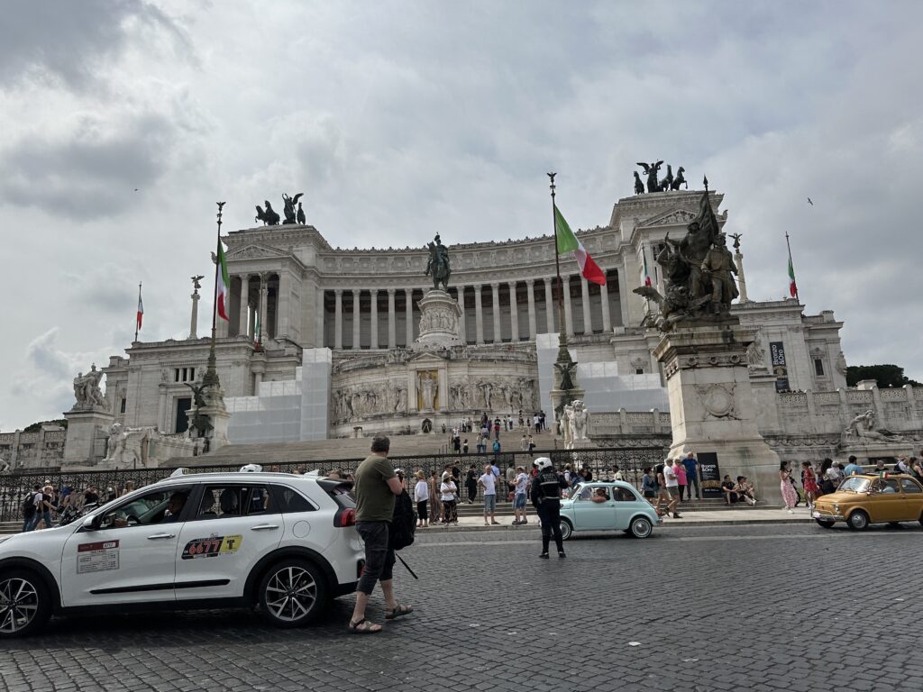 a white car in front of a building with people and cars