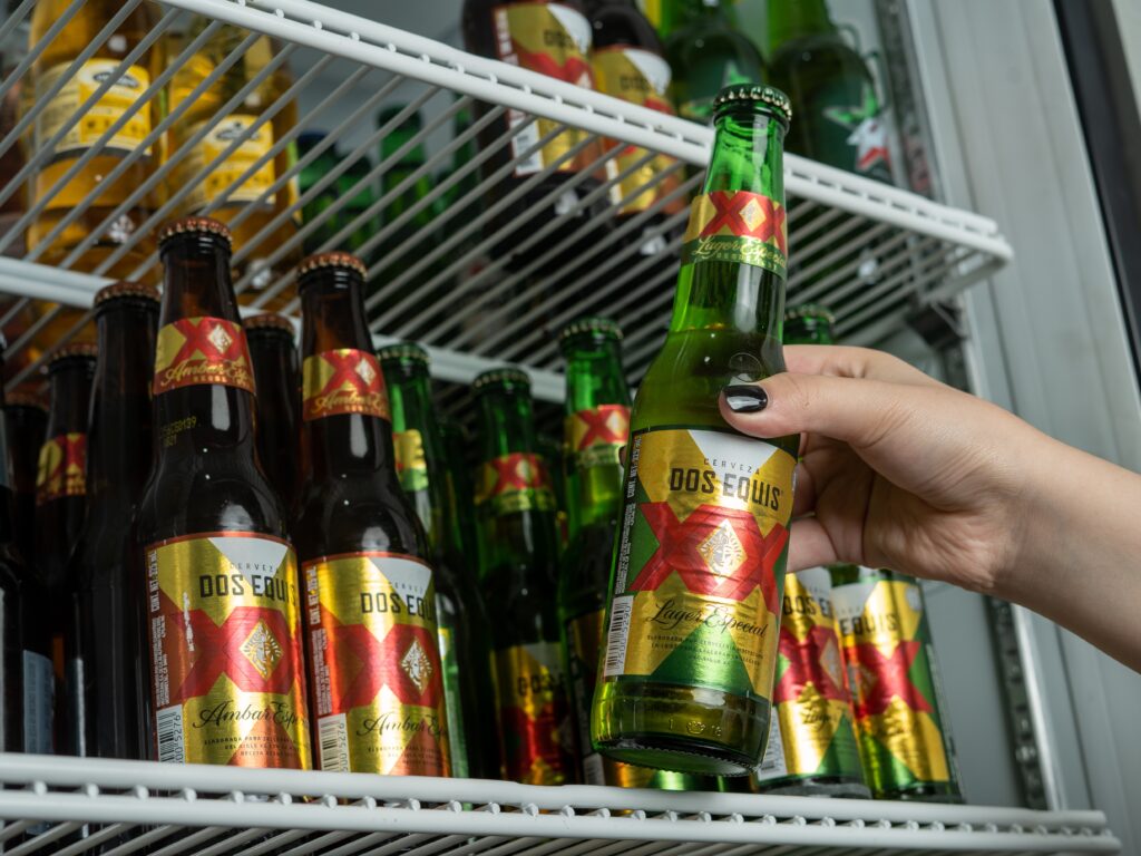a hand holding a bottle of beer