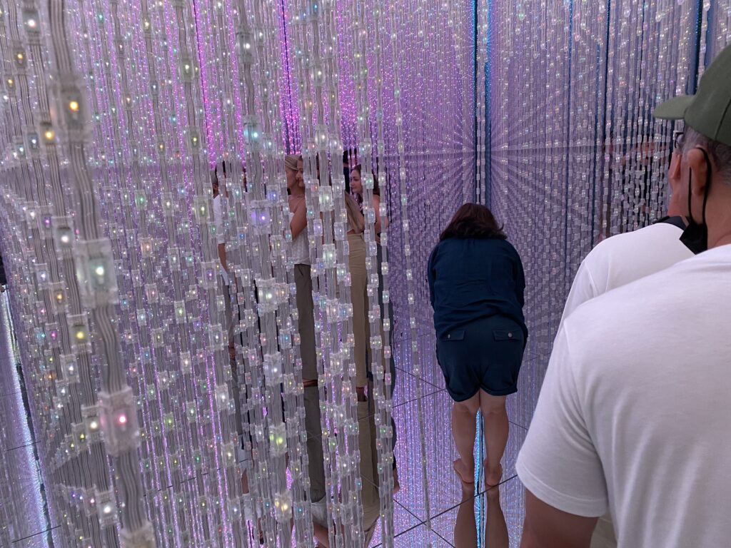 a group of people standing in a room with many lights