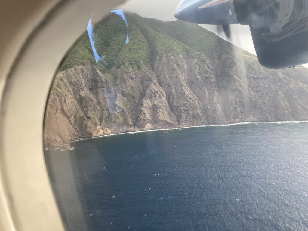 a view of a mountain and body of water from an airplane window
