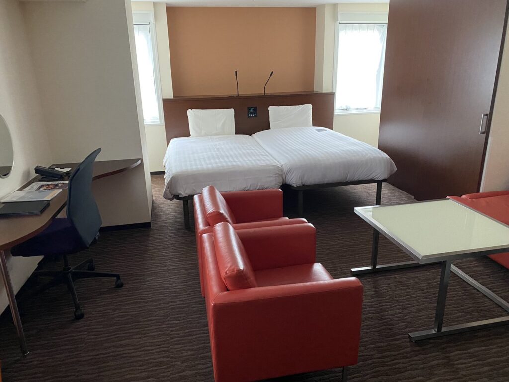 a room with two beds and a desk