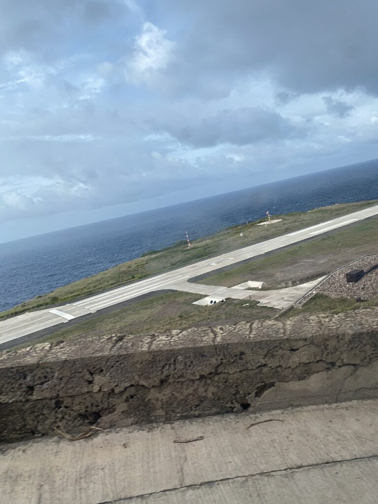 an airport runway on a grassy island with water in the background