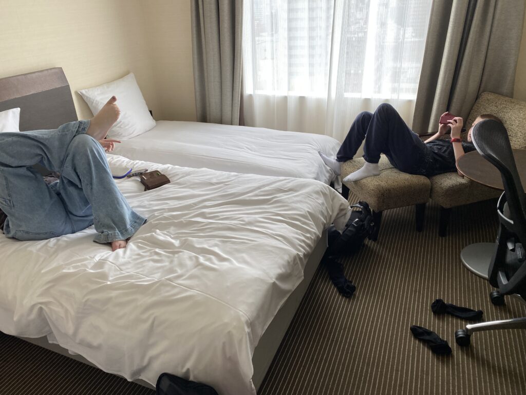a couple of people sitting on a bed in a hotel room