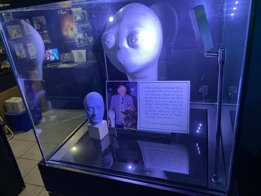 a statue of an alien in a glass case