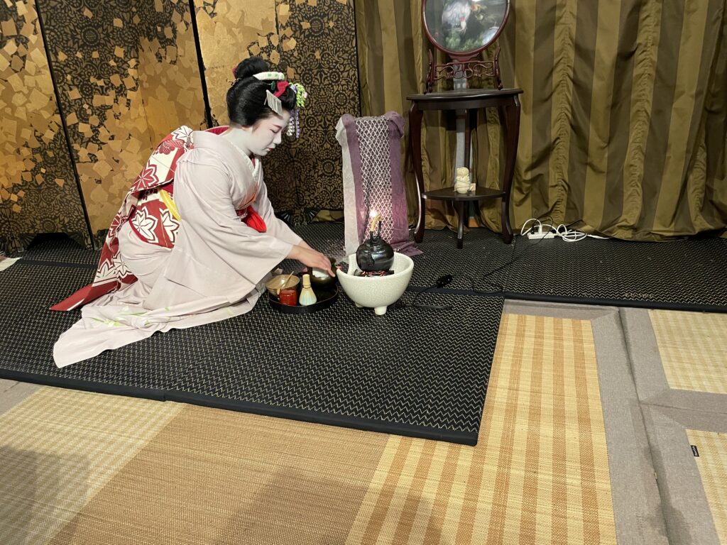 a woman in a kimono sitting on a mat