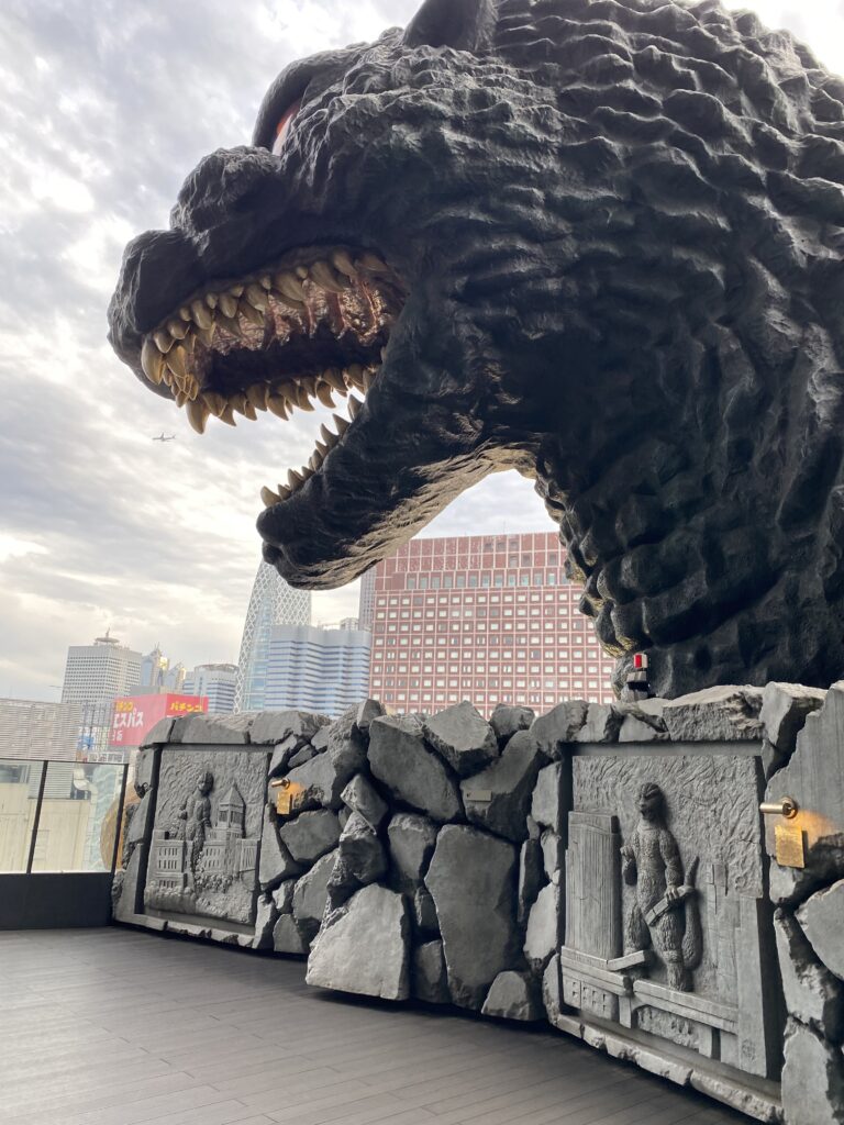 a statue of a dinosaur with a city in the background