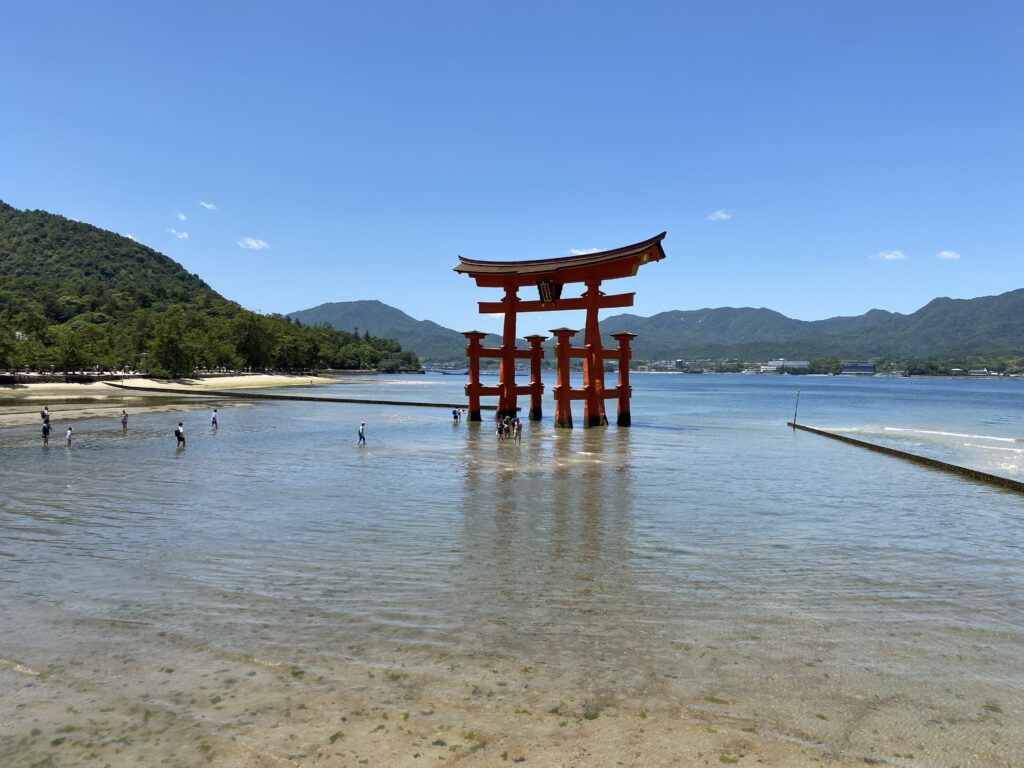 a structure in the water with Itsukushima in the background