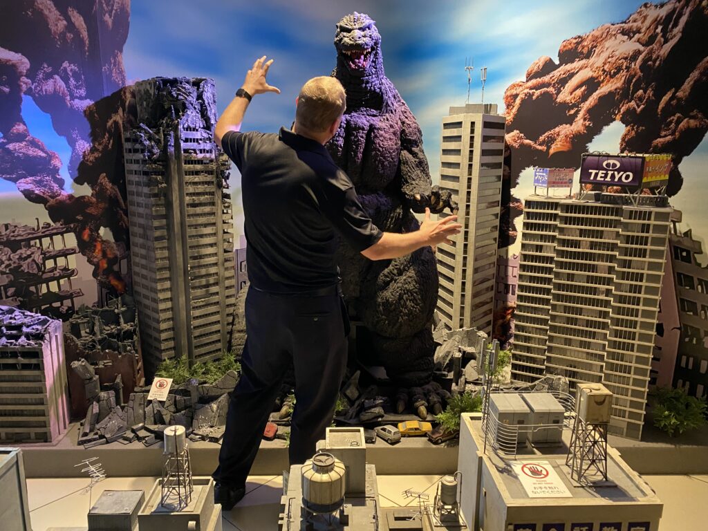a man standing in front of a model of a monster