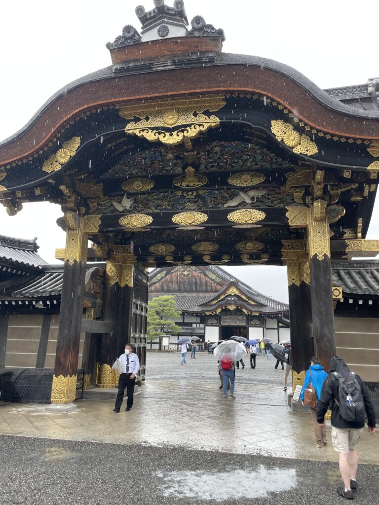 a large black and gold covered building with people walking around