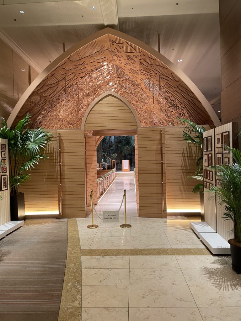 a room with a large arched doorway and palm trees