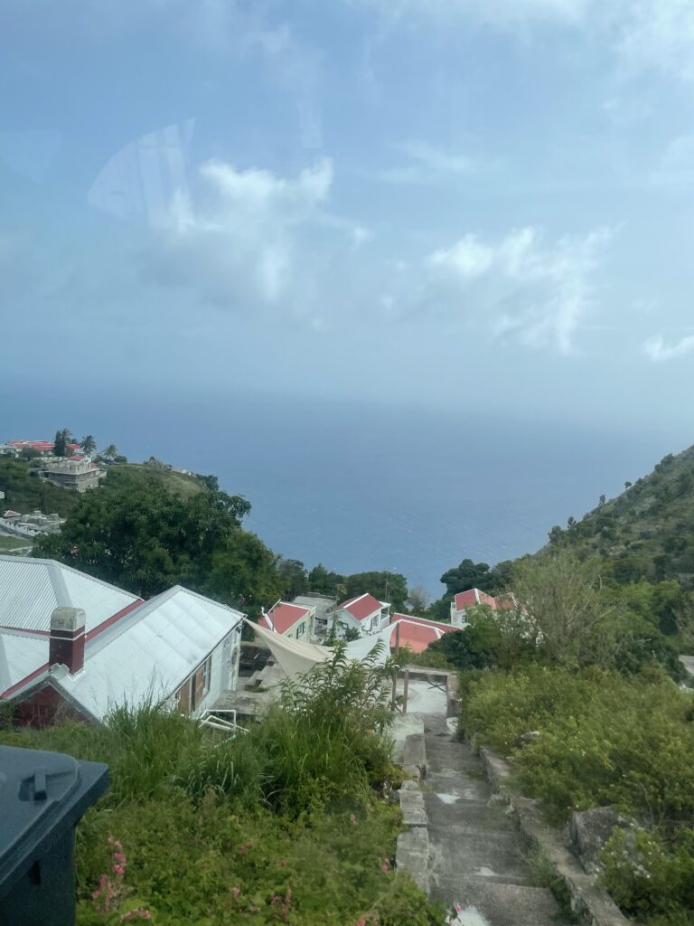 a view of a hill with houses and a body of water