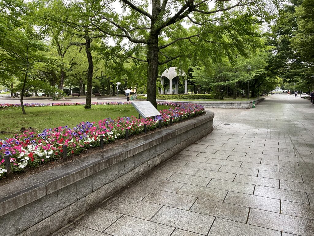 a stone walkway with flowers and trees