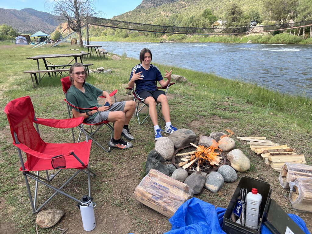 two people sitting around a fire