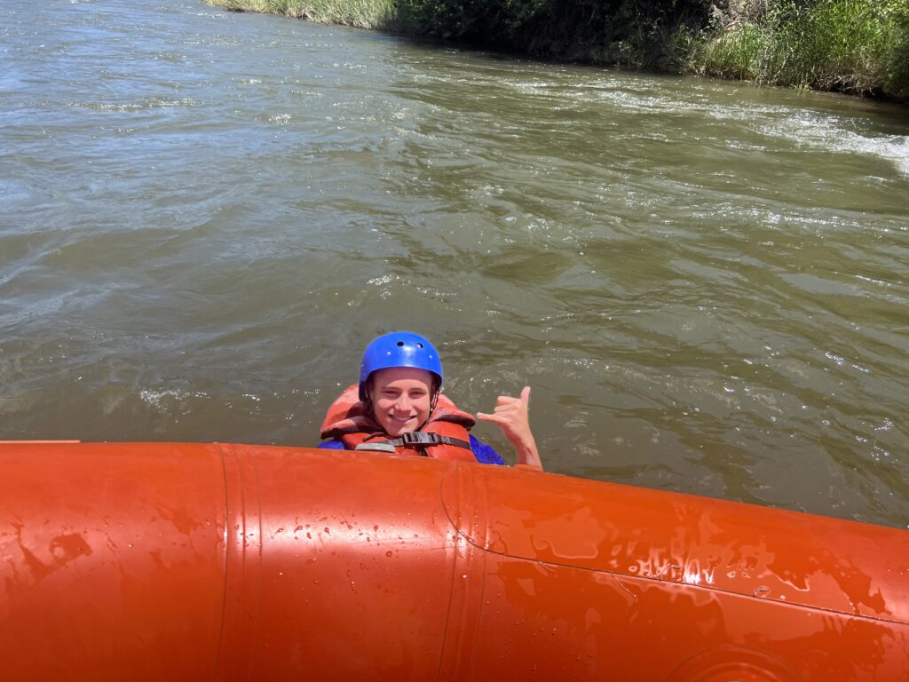 a person in a blue helmet on a raft in a river