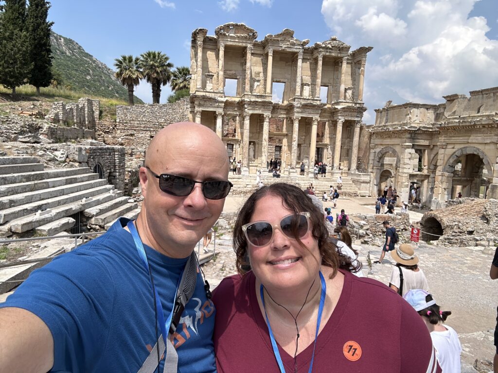 a man and woman taking a selfie in front of an ancient ruins