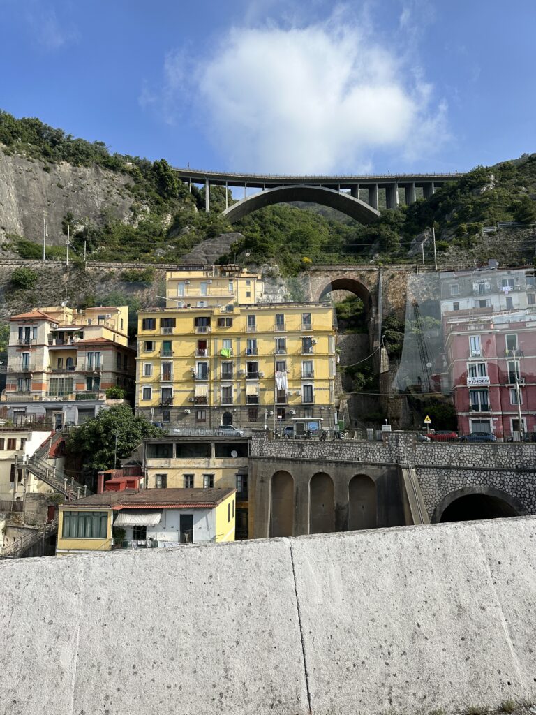 a bridge over a hill with buildings and trees