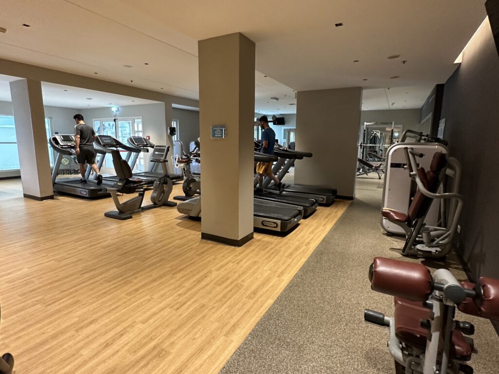 a gym with treadmills and people walking