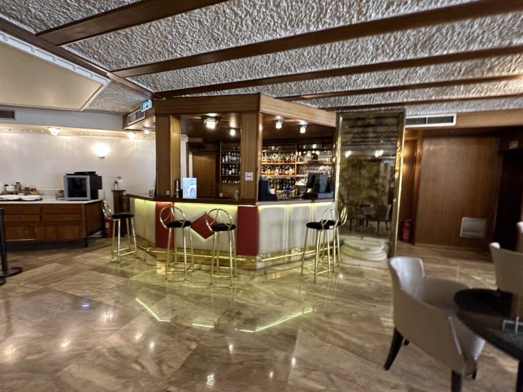 a bar with stools and a mirror in a room
