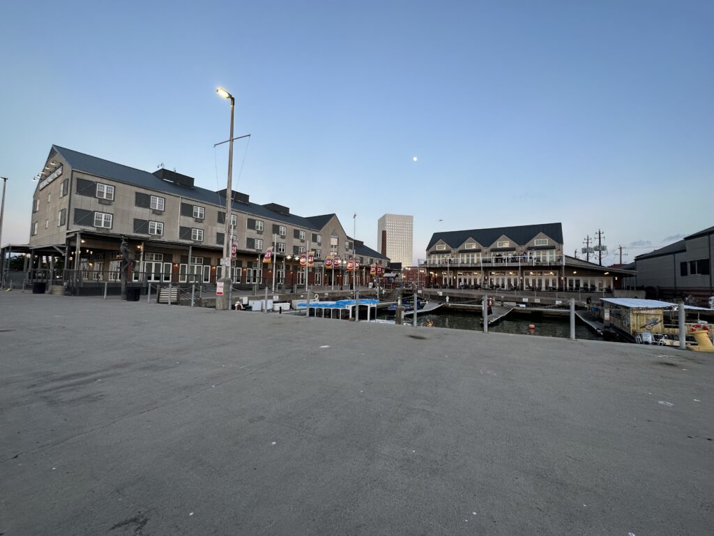 a dock with boats and buildings in the background