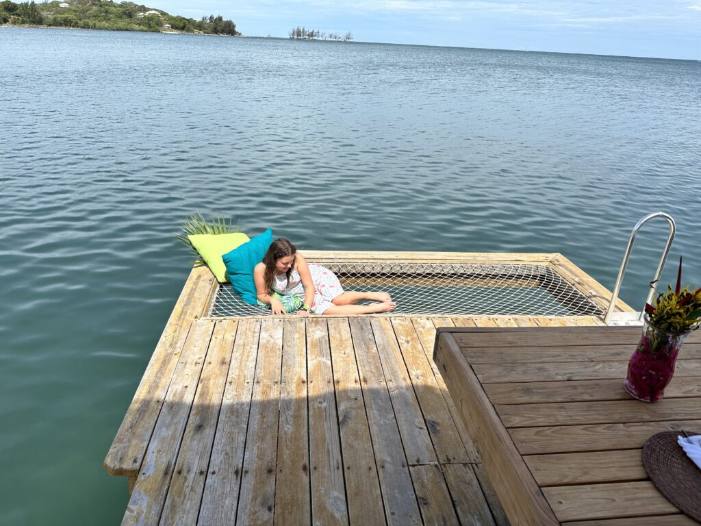 a girl lying on a dock over water