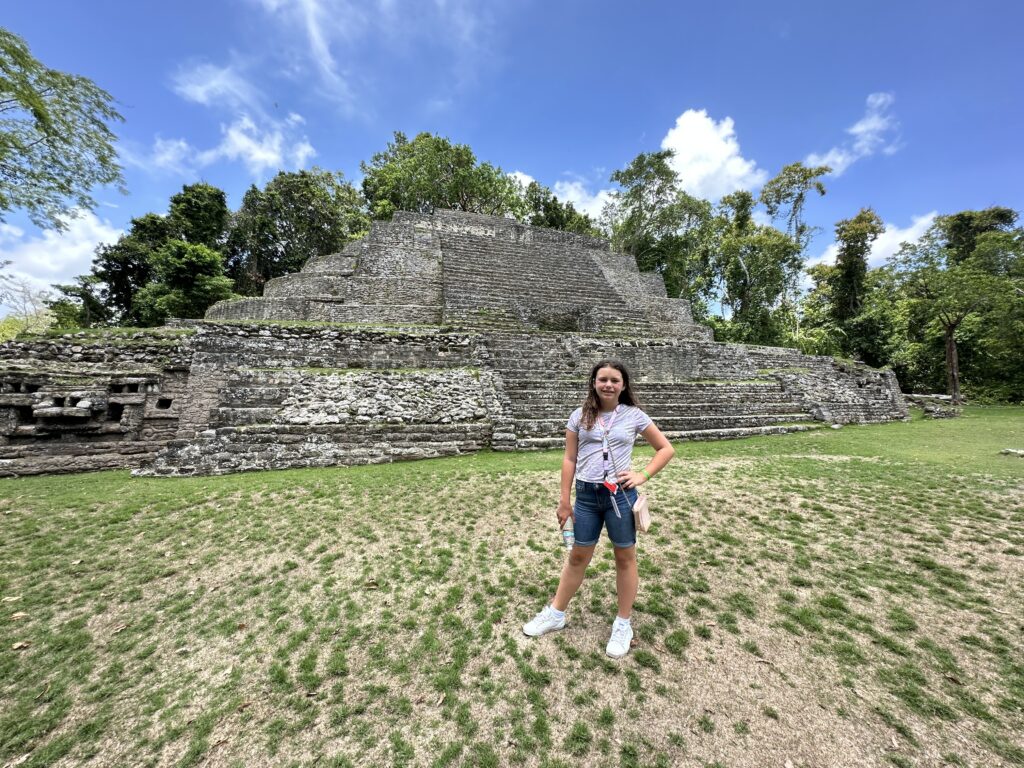 a girl standing in front of a pyramid