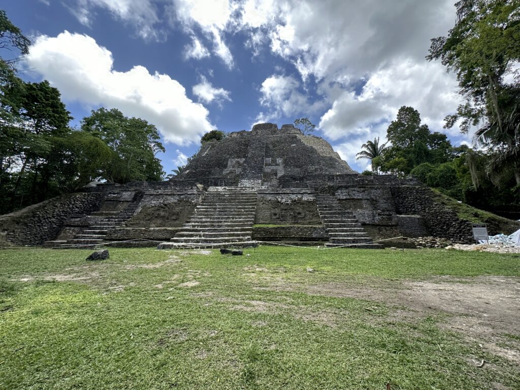 a stone pyramid with steps and a grassy field