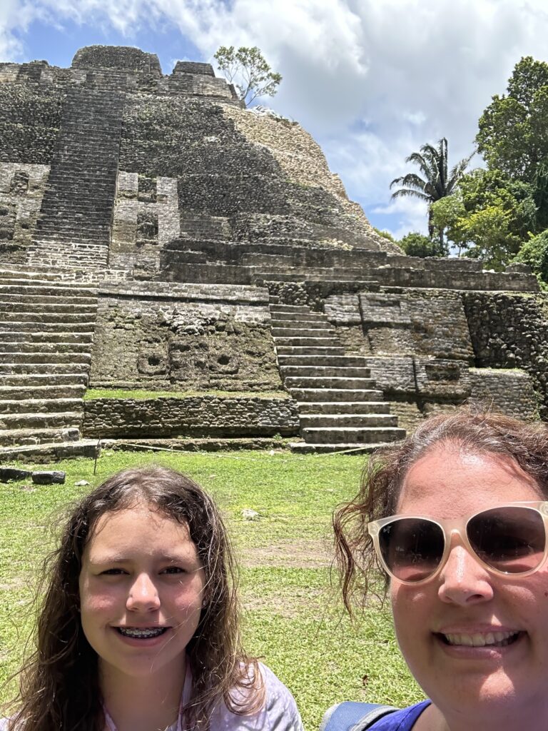 two women taking a selfie in front of a stone pyramid