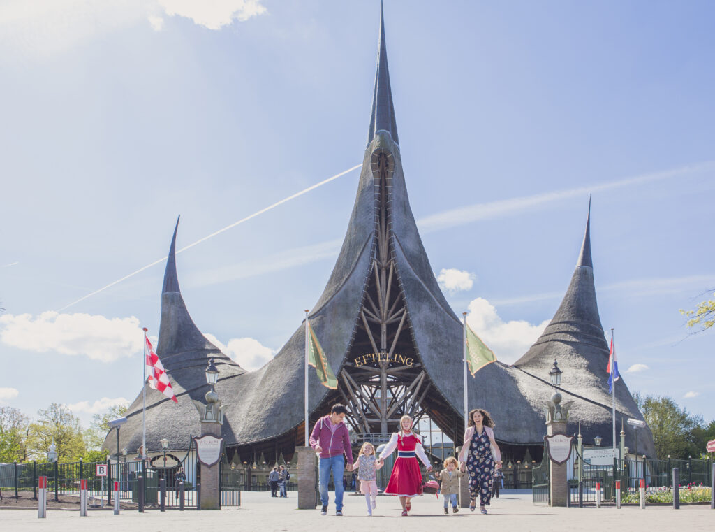 a group of people in front of a large building with Efteling in the background