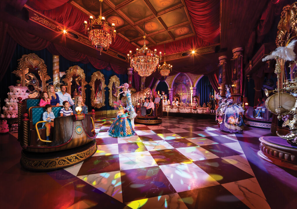 a group of people in a room with a mirror and chandelier