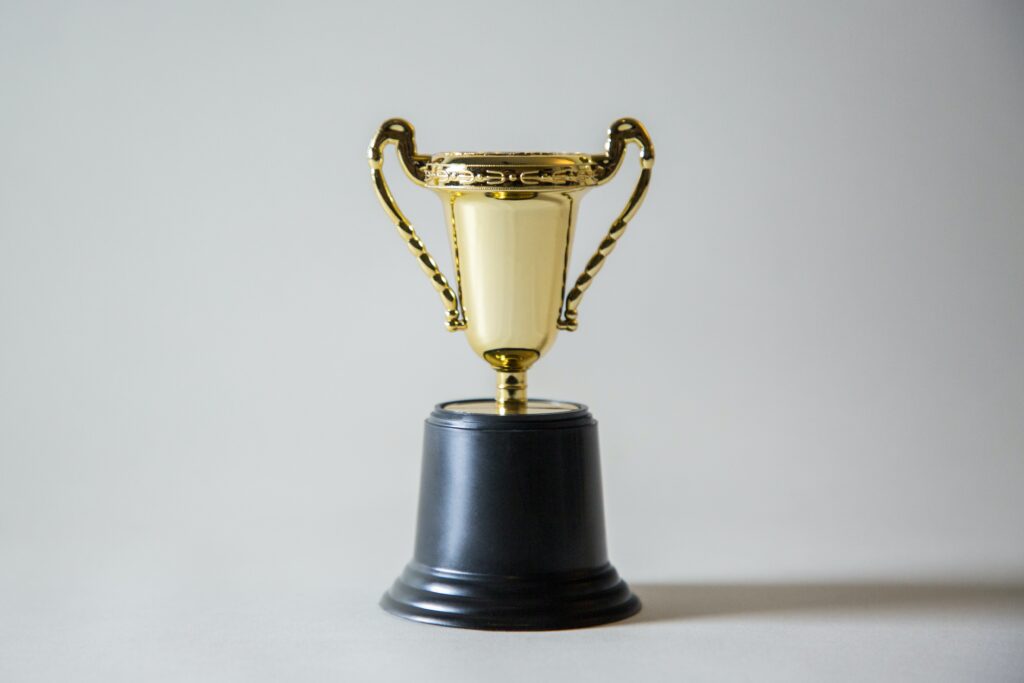 a gold trophy on a black base