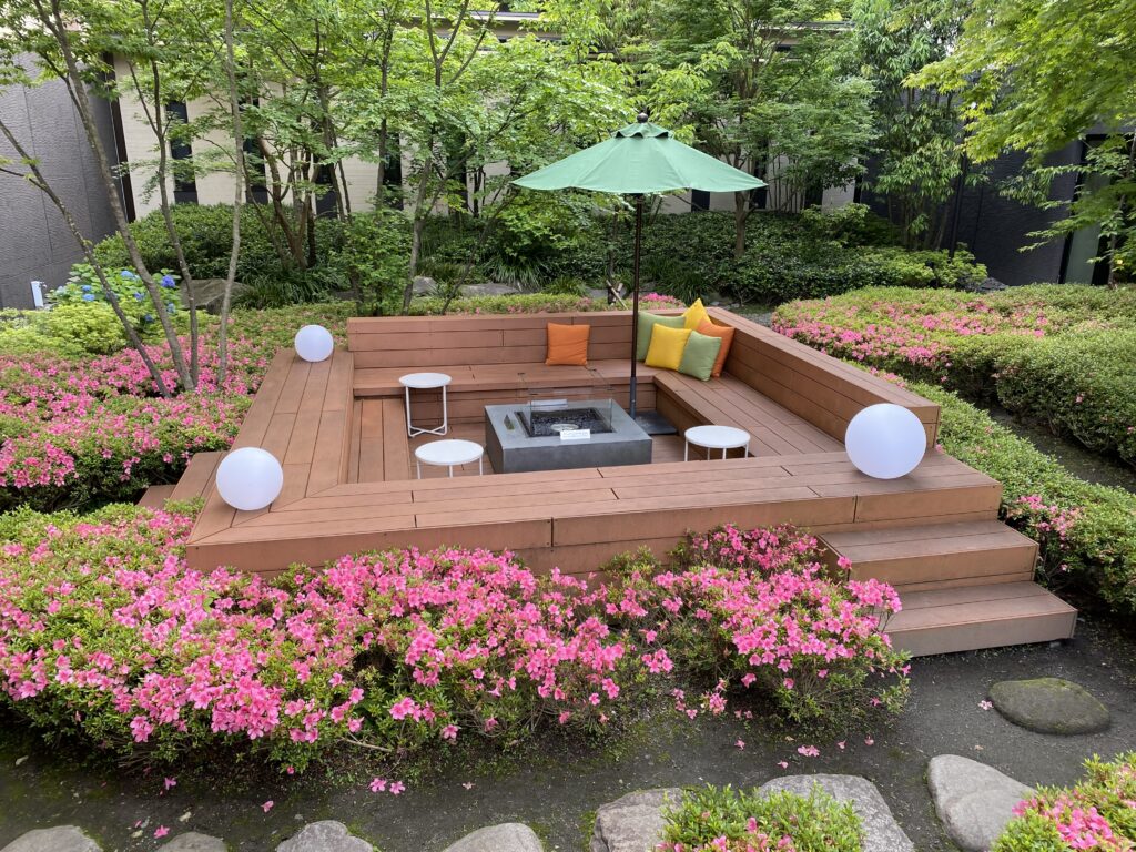 a wood deck with a fire pit and flowers