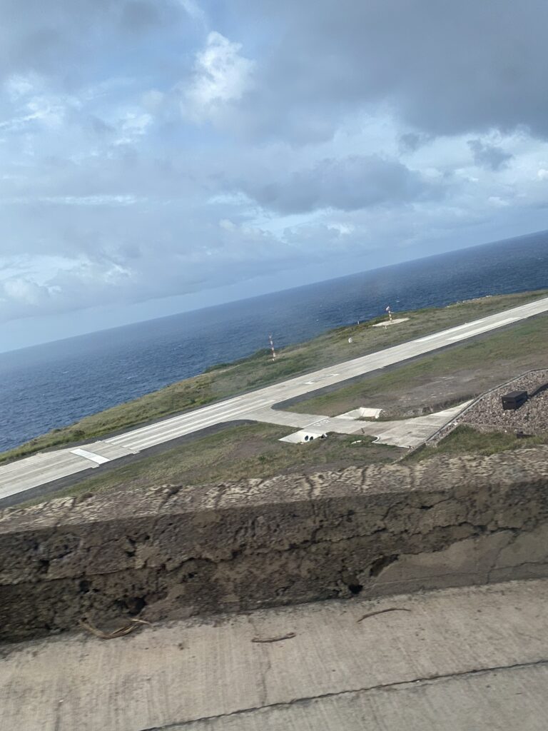 an airport runway on a grassy island with water in the background