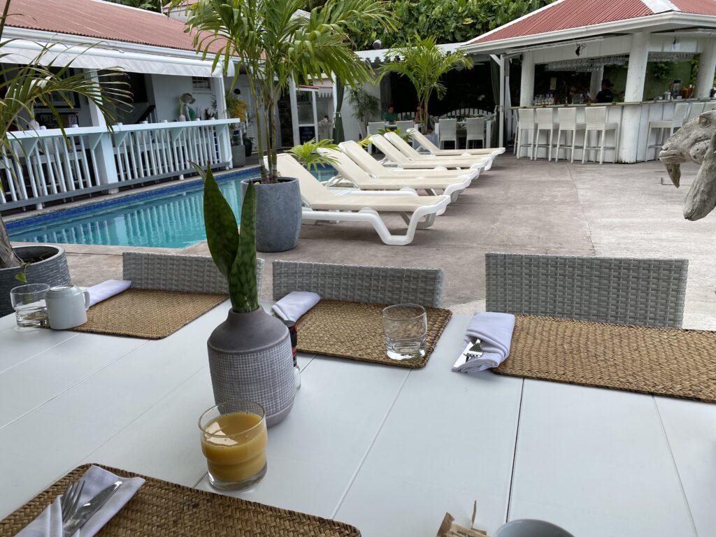 a table with chairs and a pool in the background