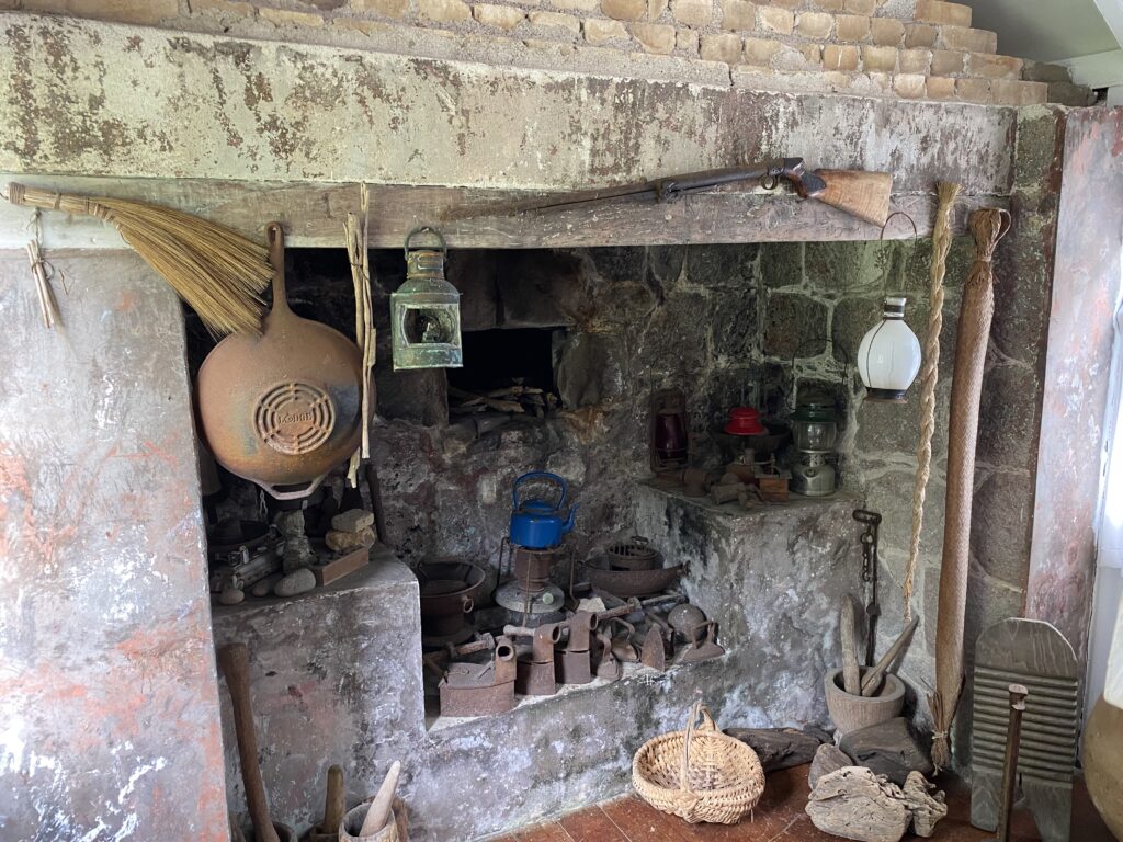 a stone fireplace with a gun and a broom