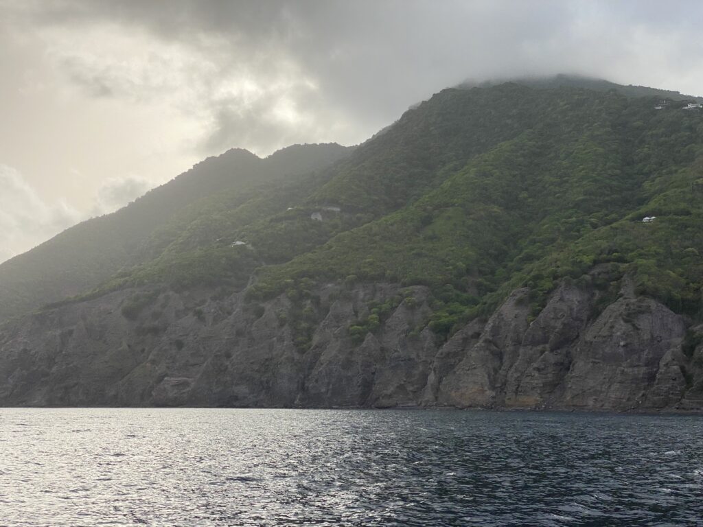 a body of water with a mountain and clouds