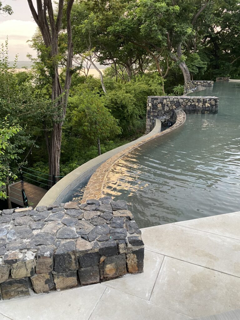 a stone wall next to a body of water