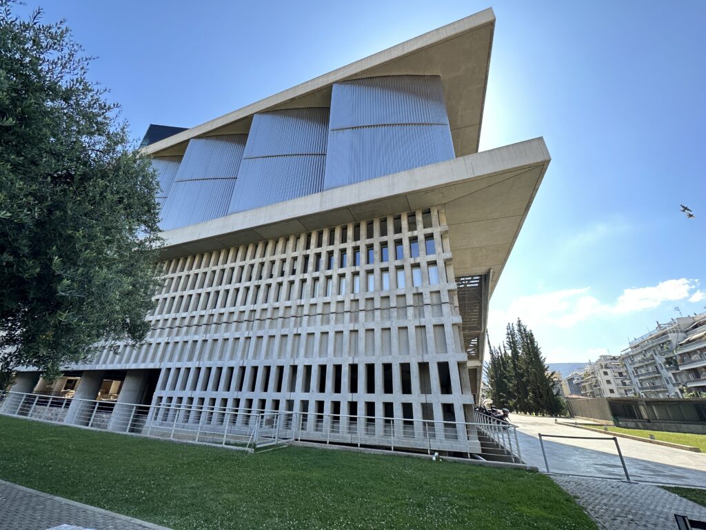 a building with a green lawn and trees