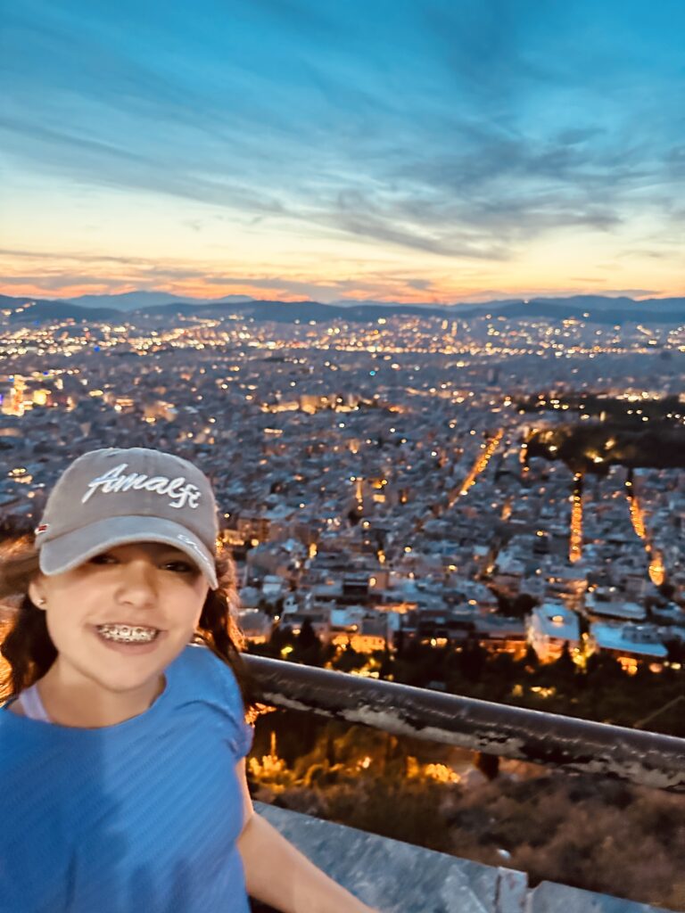 a woman taking a selfie with a city in the background