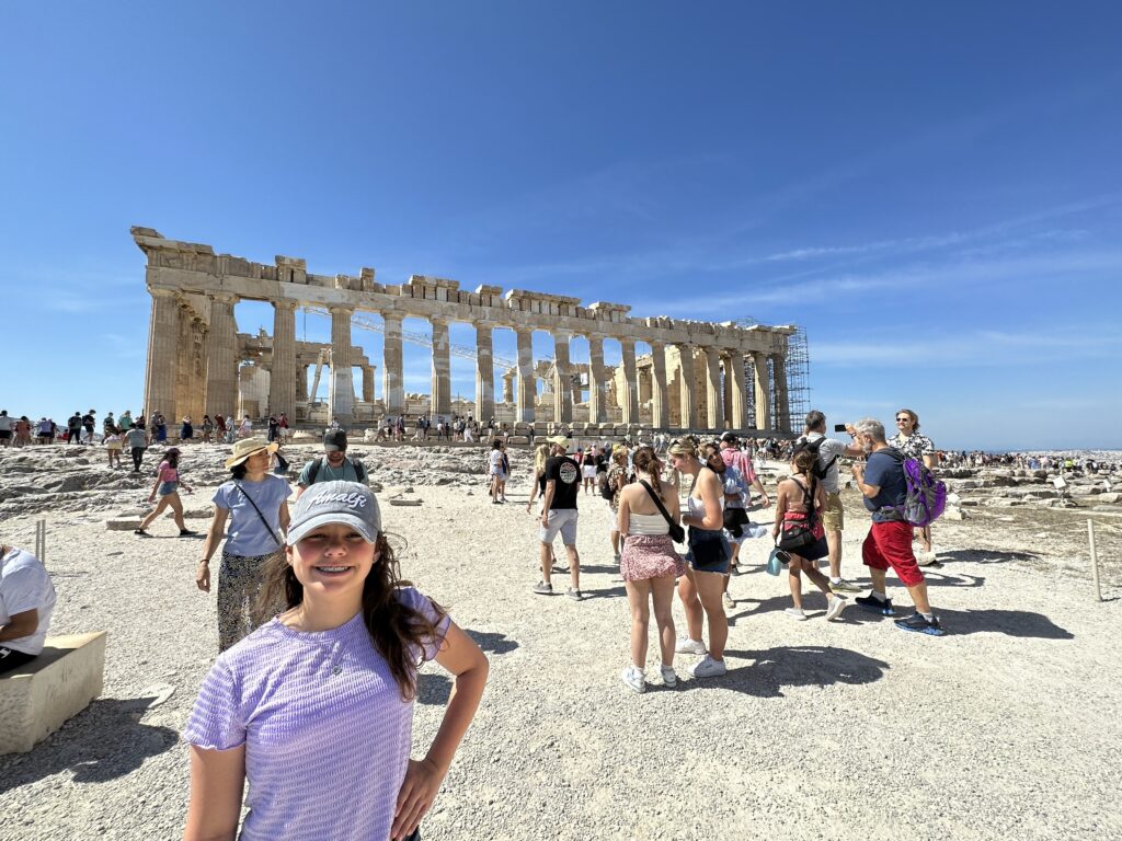 a woman standing in front of a large stone building