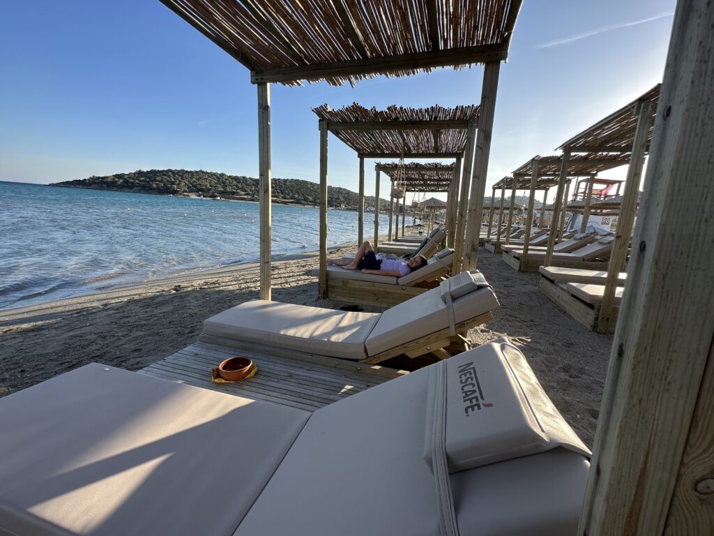a group of lounge chairs on a beach