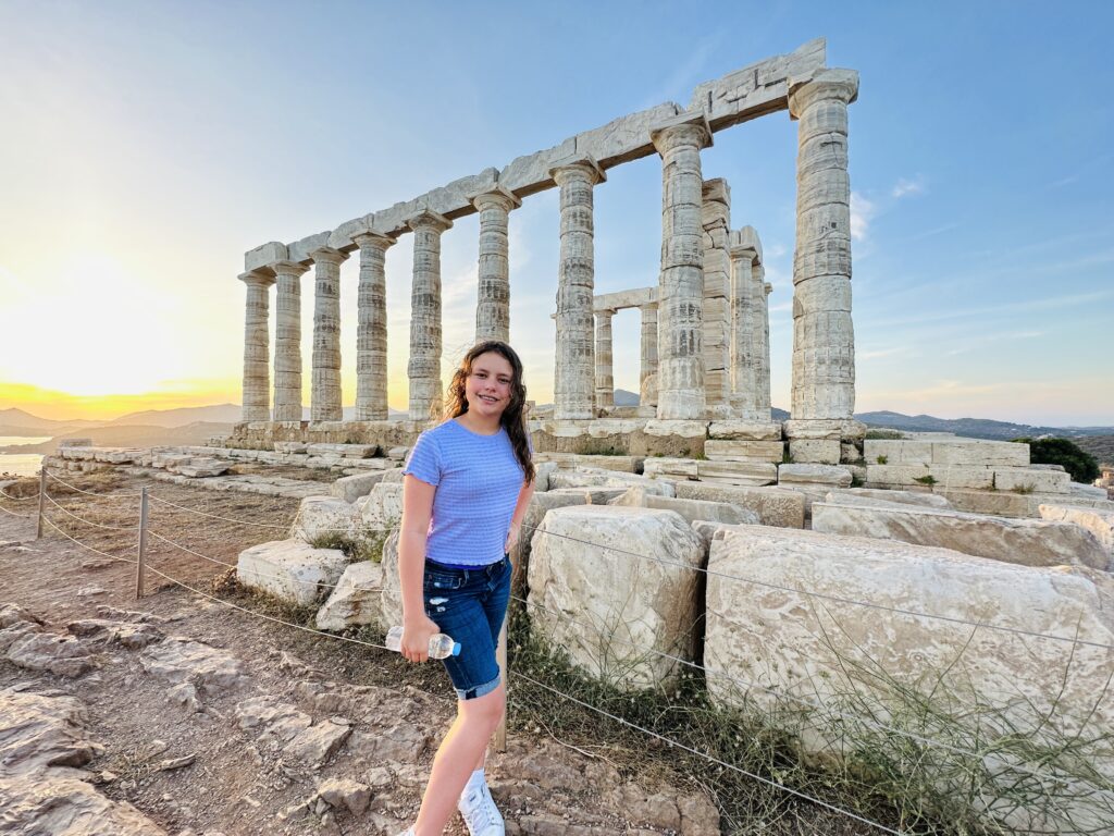 a girl standing in front of a stone structure