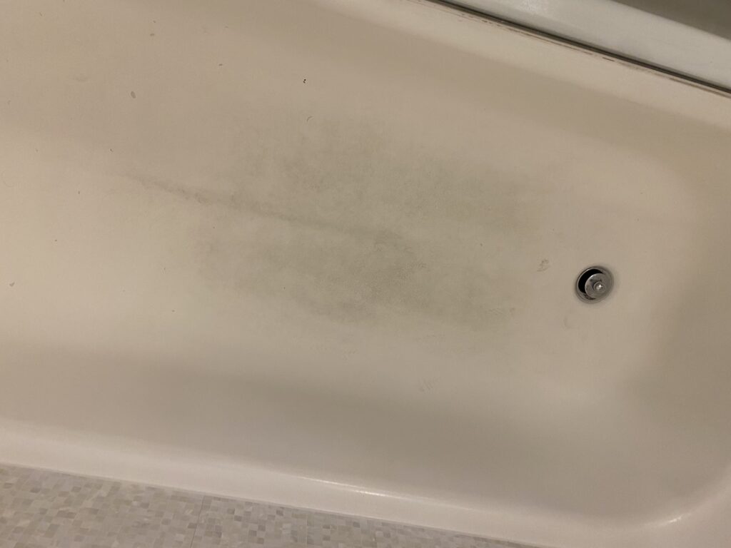 a white bathtub with a silver drain
