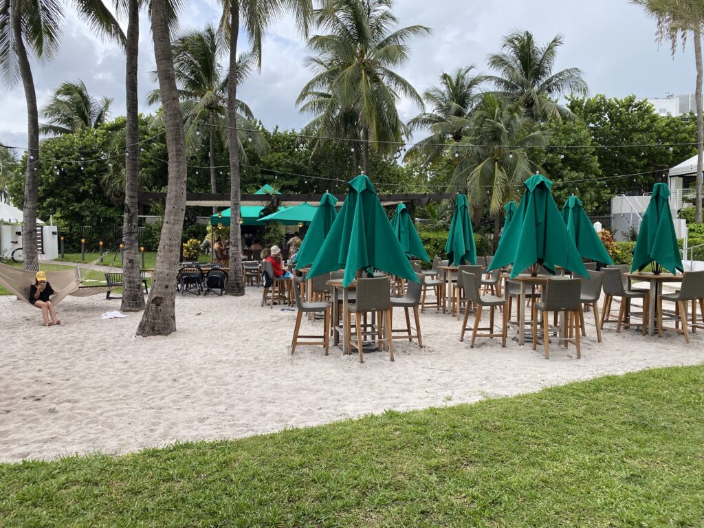 a group of chairs and tables with umbrellas in a beach area