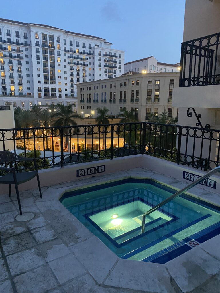a hot tub with a railing and a railing in front of a building