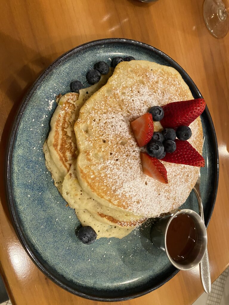 a plate of pancakes with strawberries and blueberries