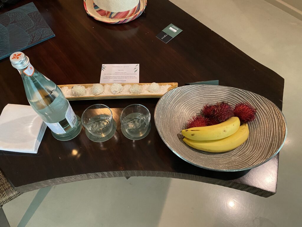 a bowl of bananas and two glasses of water on a table