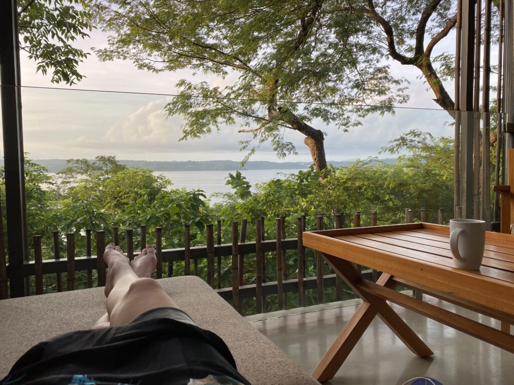 a person lying on a deck with a table and a view of water